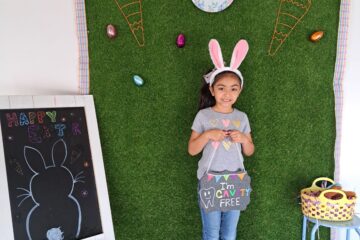 child holding ur smile dental board at halloween party